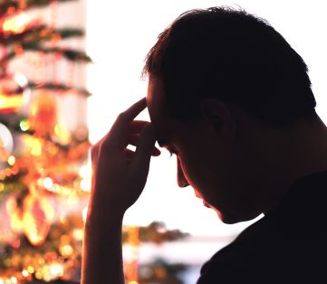 silhouetted man looking depressed at christmas time