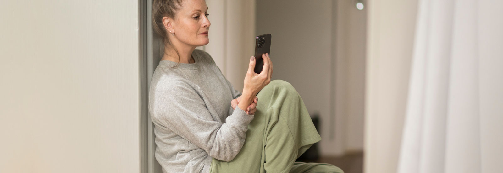 Woman in her 40s access virtual mental health services on her phone