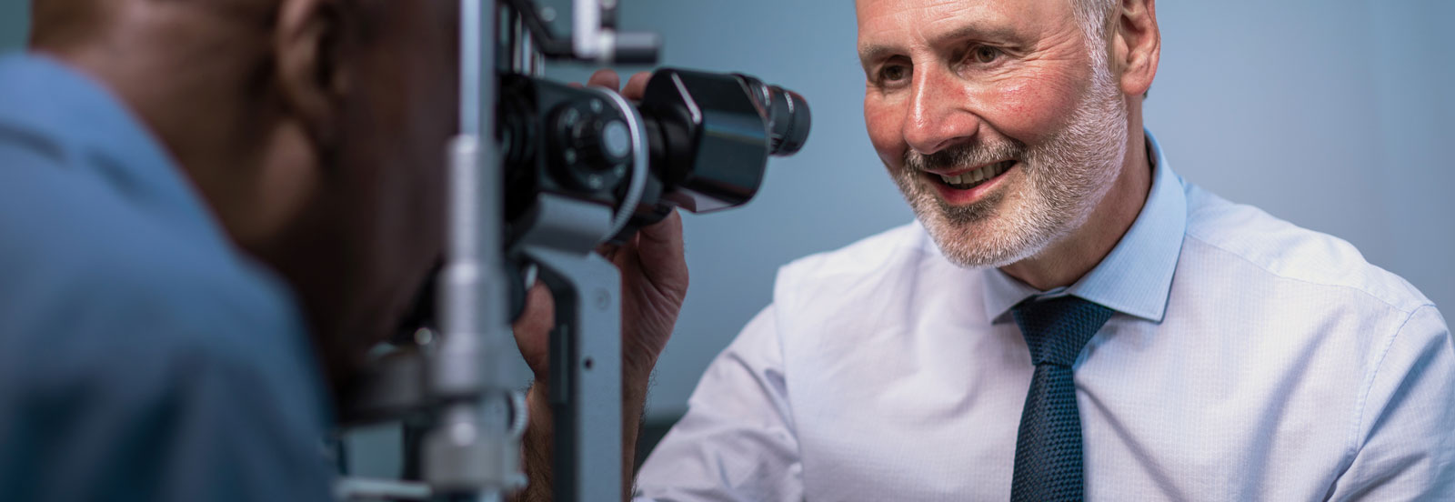 Smiling consultant performing an eye test