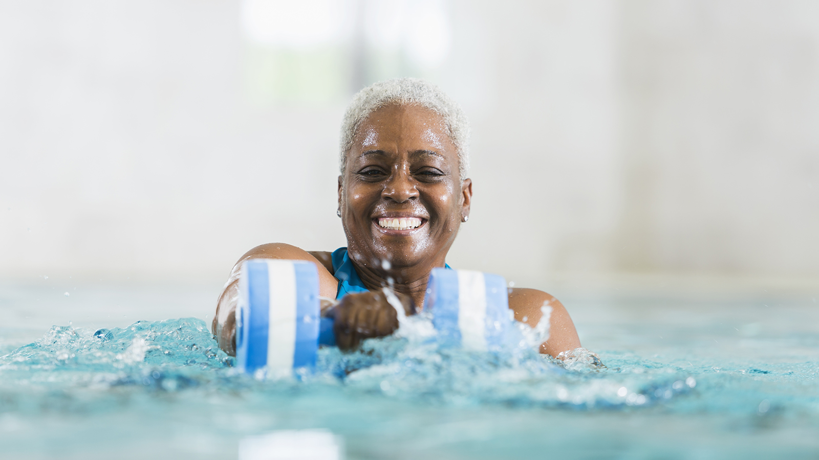 older woman doing aquarobics to manage arthritis pain