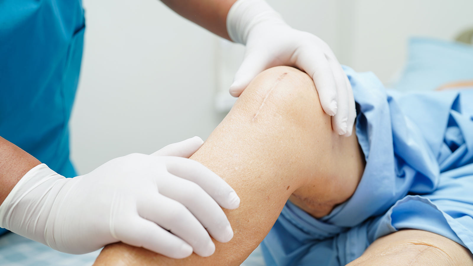 surgeon inspecting a knee after knee replacement surgery
