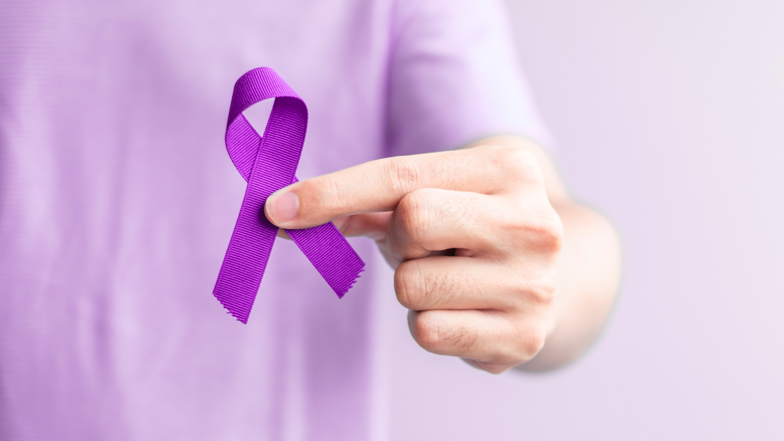 person holding the purple ribbon for testicular cancer