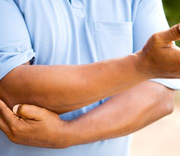 Man experiencing elbow pain due to arthritis - types of arthritis