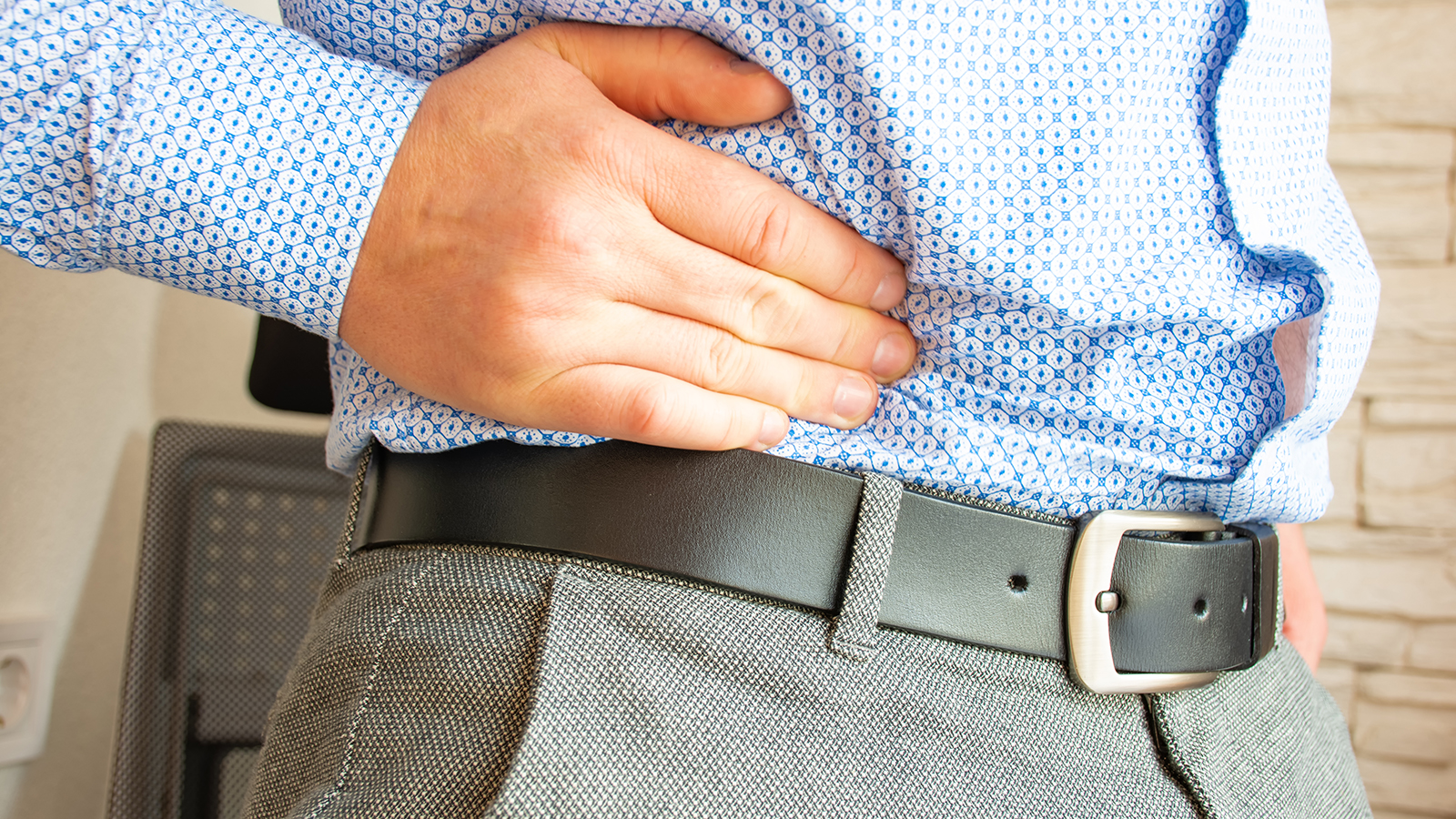 person clutching their side due to hernia pain