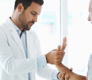 Consultant examining man's wrist - why does my wrist hurt?