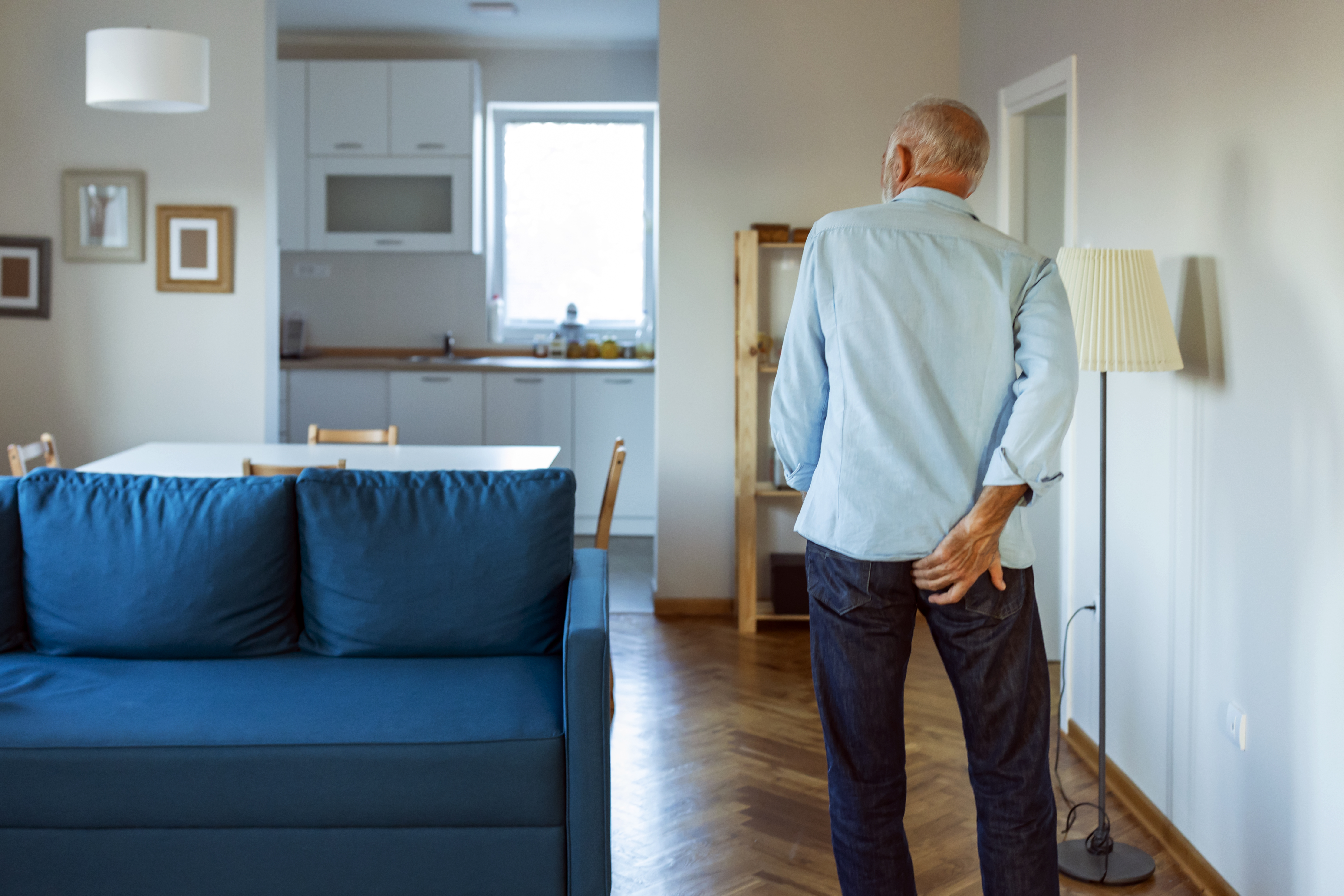 A man holding his pack passage walking uncomfortably to the bathroom