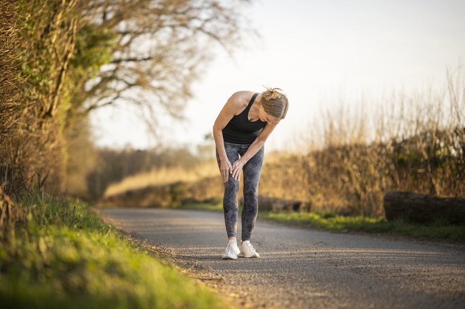 woman holding leg due to knee pain while exercising