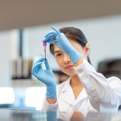 Healthcare professional examining a blood sample in a laboratory setting