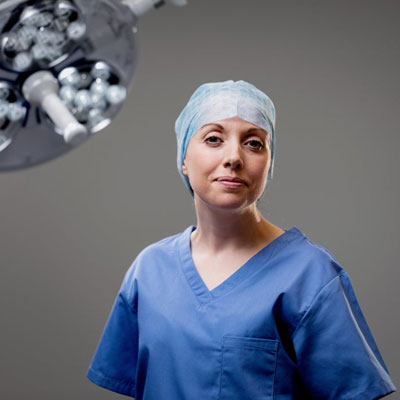 Clinical staff wearing surgical clothing standing in an operating theatre