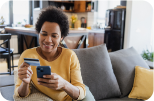 smiling woman holding bank card and phone