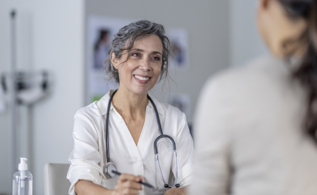 Consultant discussing early signs and symptoms of cancer with female patient