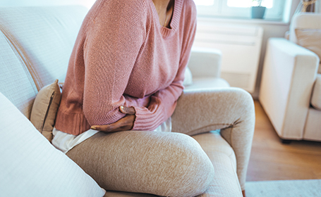 woman experiencing stomach cramps due to crohn's or colitis