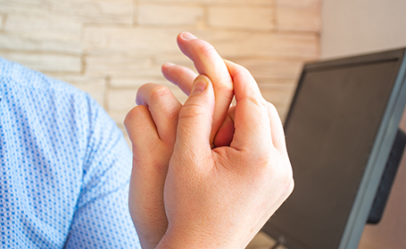person at work suffering with trigger finger symptoms