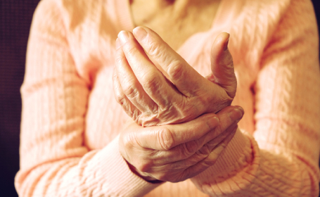 Woman experiencing pain in her wrist due to arthritis - types of arthritis