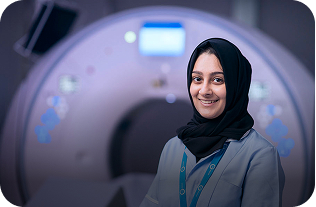 smiling member of private hospital staff standing in front of scanner