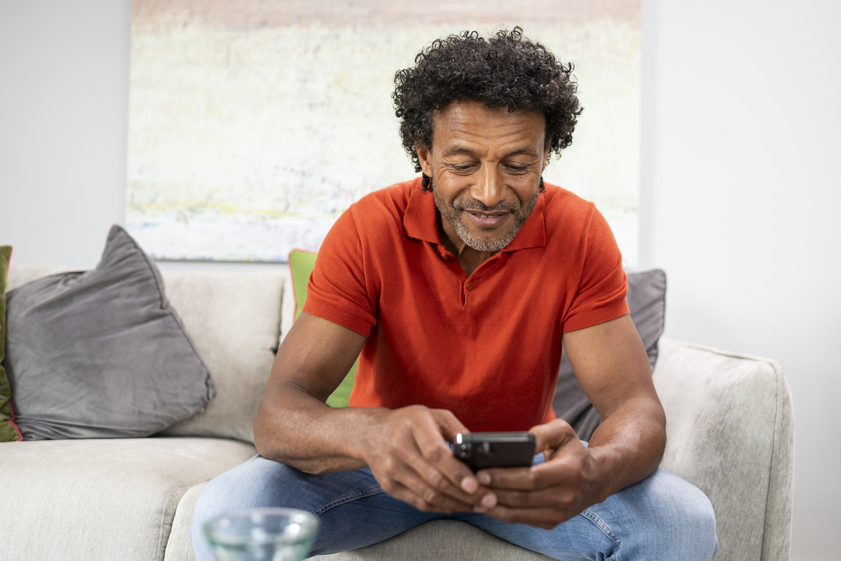 Man smiling while using phone device 