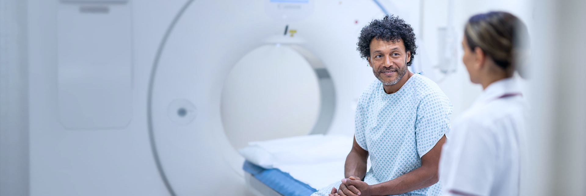 patient and private hospital staff member next to scanner