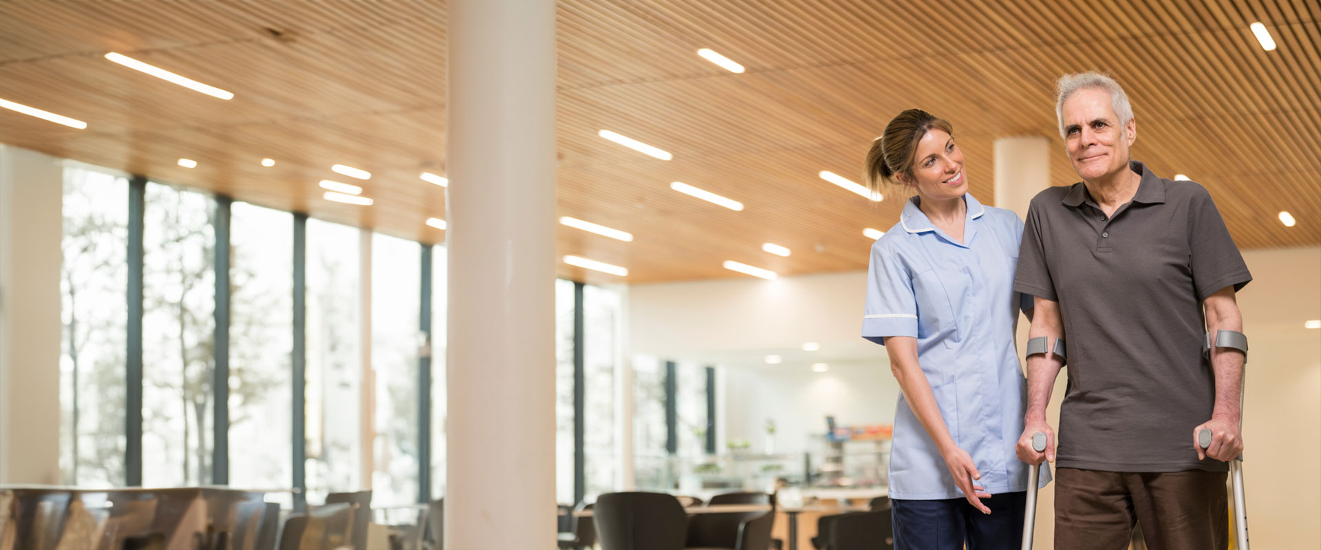 patient on crutches supported by private hospital nurse