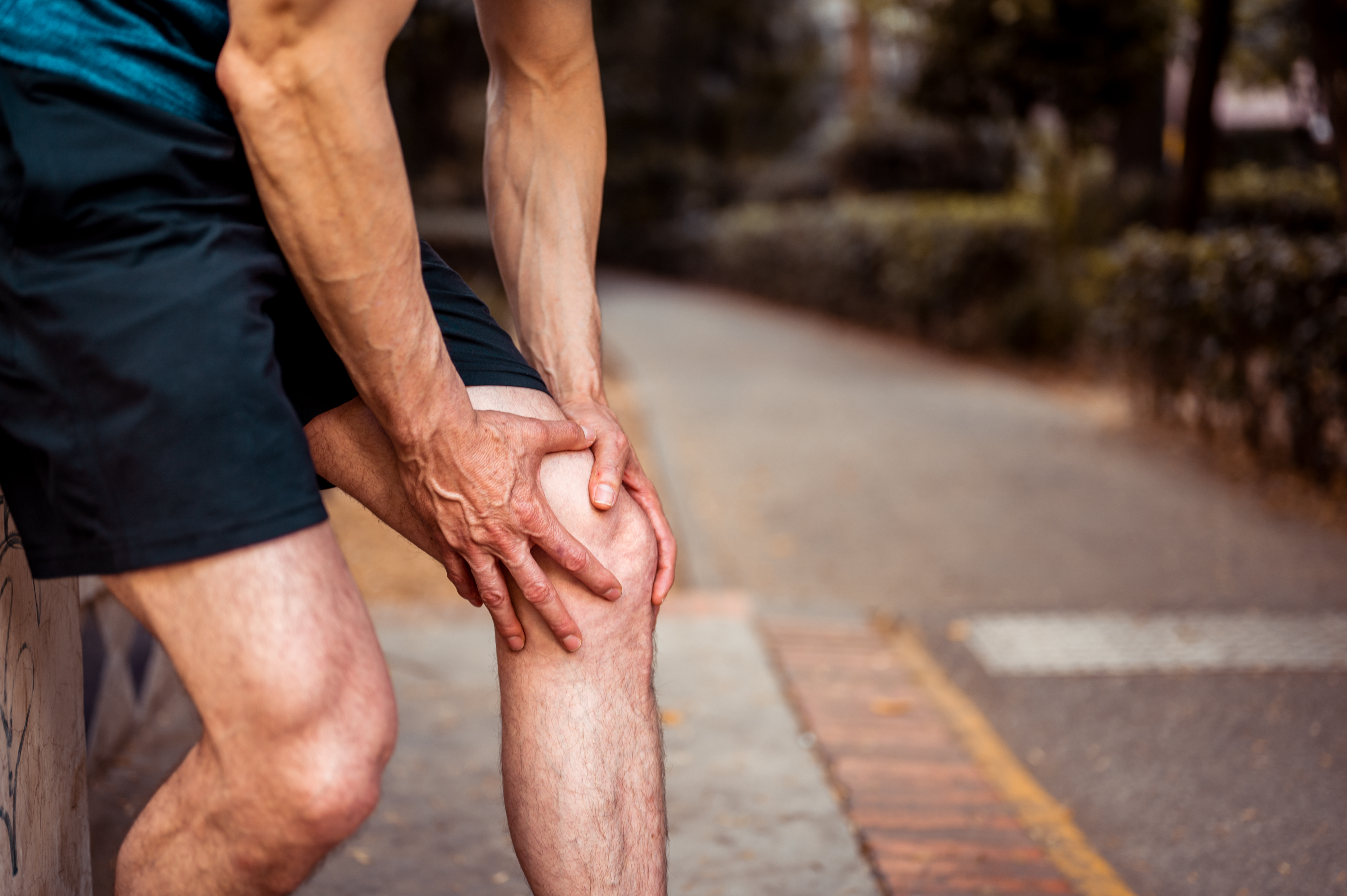An athlete holds on to his upper leg as he feels pain