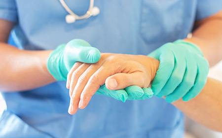 Doctor holds a patient's hand after administering a local anaesthetic