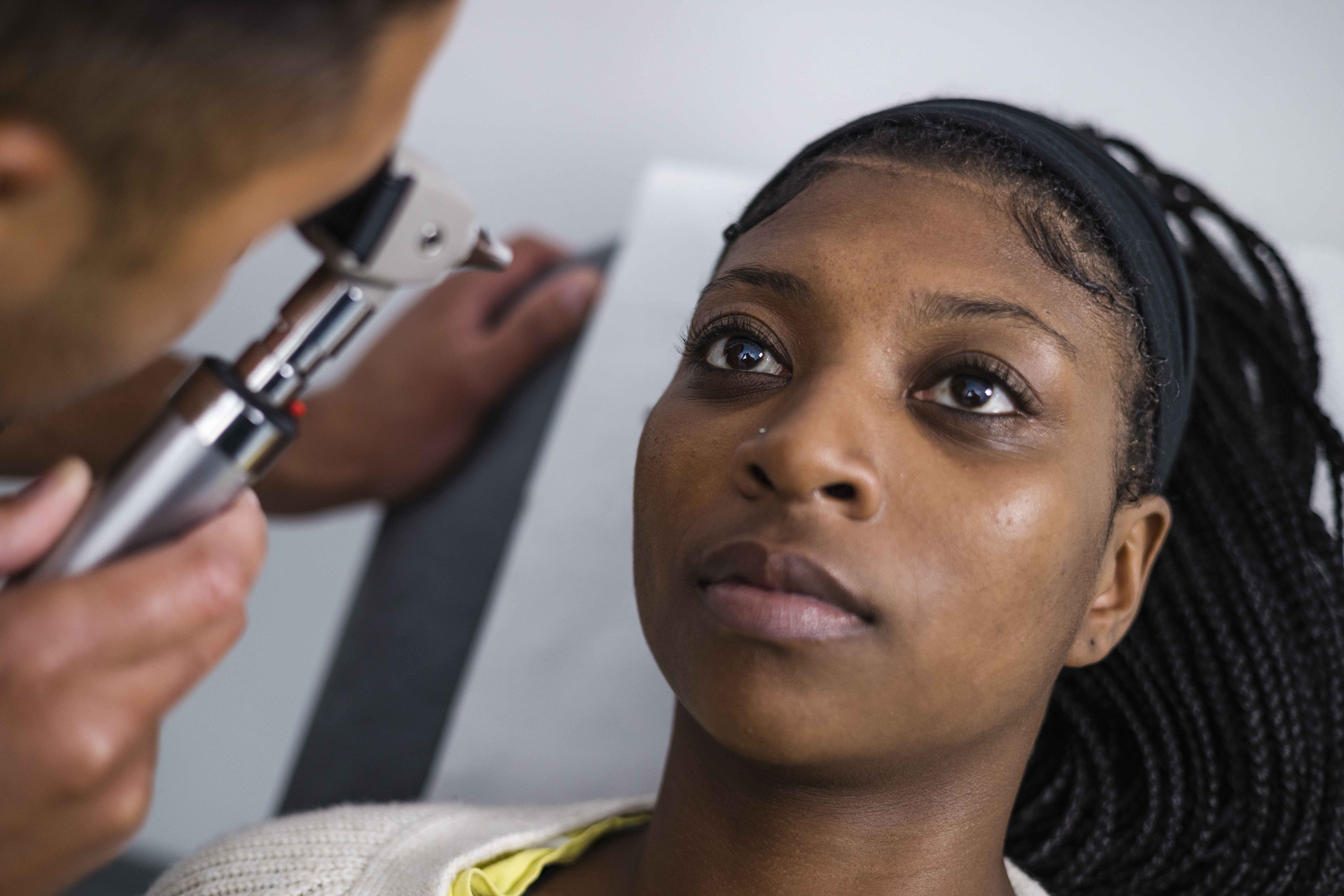 A woman having her eye examined by a healthcare professional