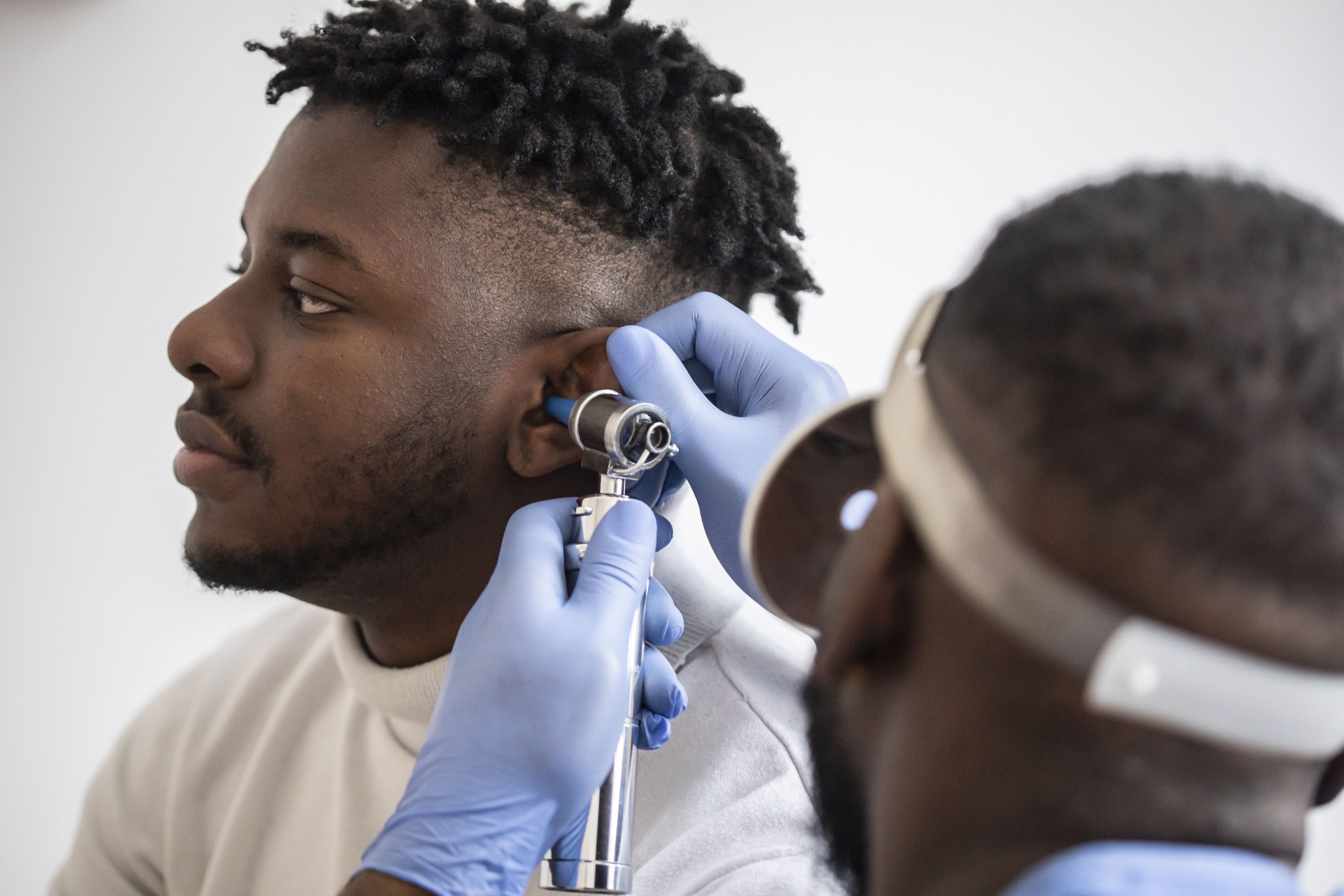 A man's ear being examined by a doctor