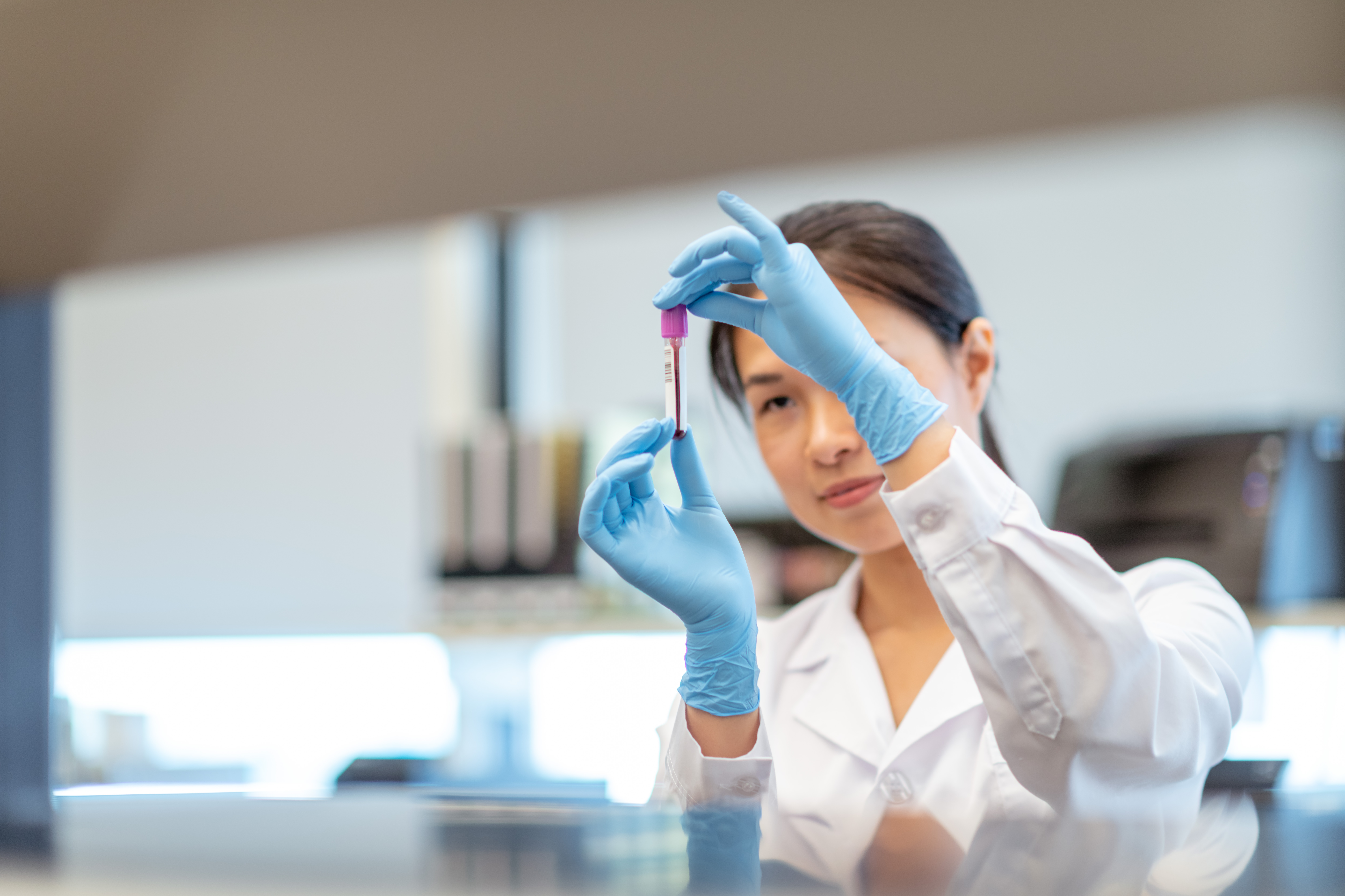 Female doctor analysing a sample in a glass vial