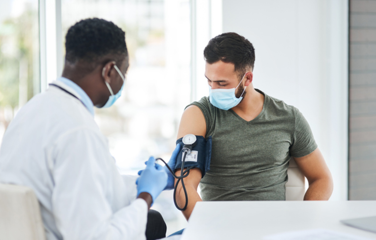 Shot-of-a-doctor-examining-a-young-man-with-a-blood-pressure-gauge