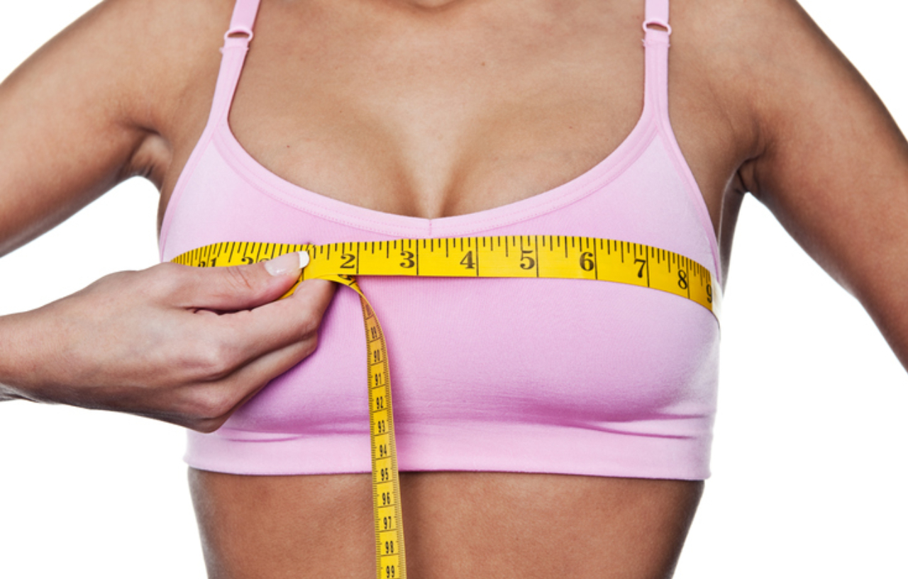 Woman measuring her bust before her breast implant removal surgery