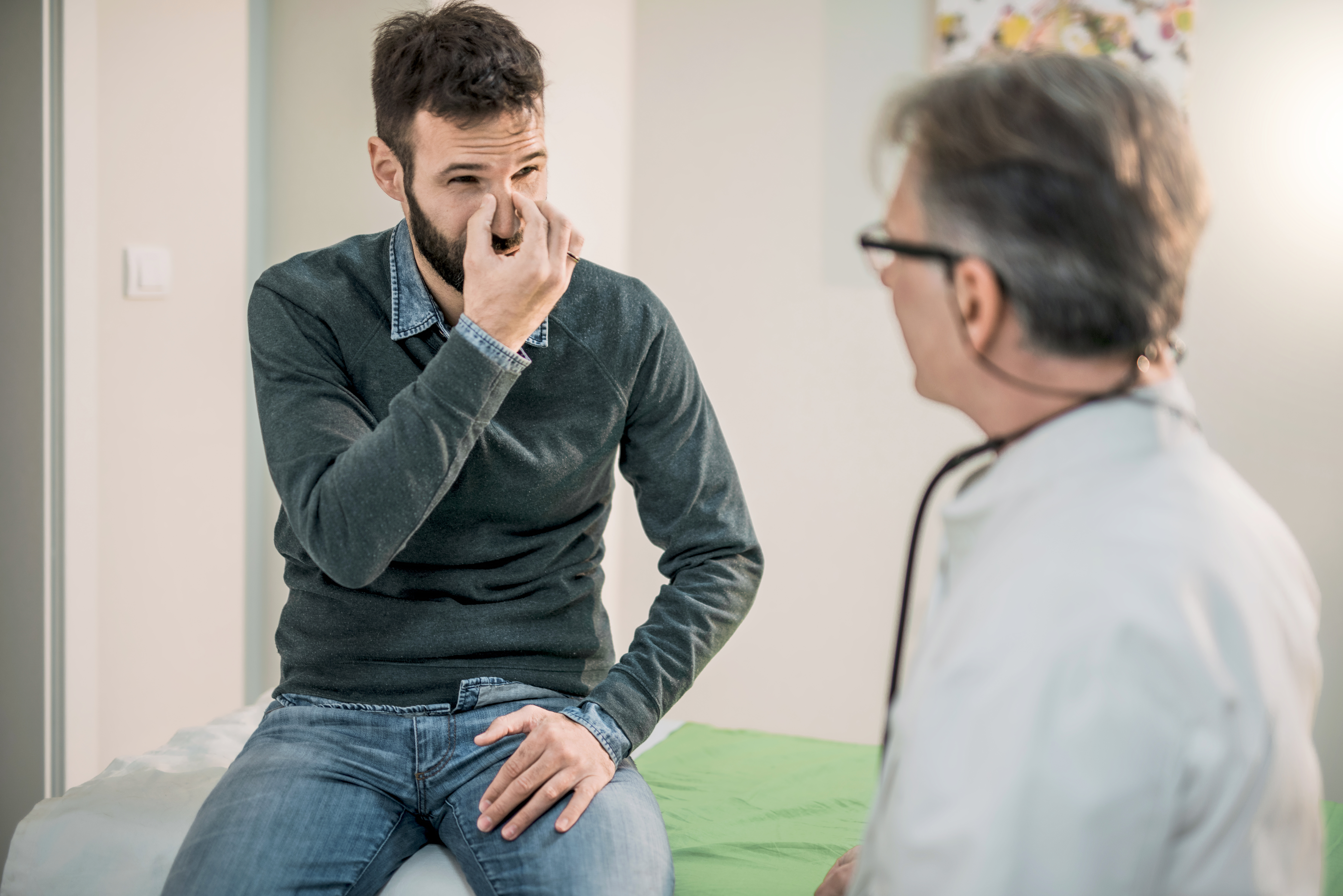 A man explains issues with his nose with a medical professional