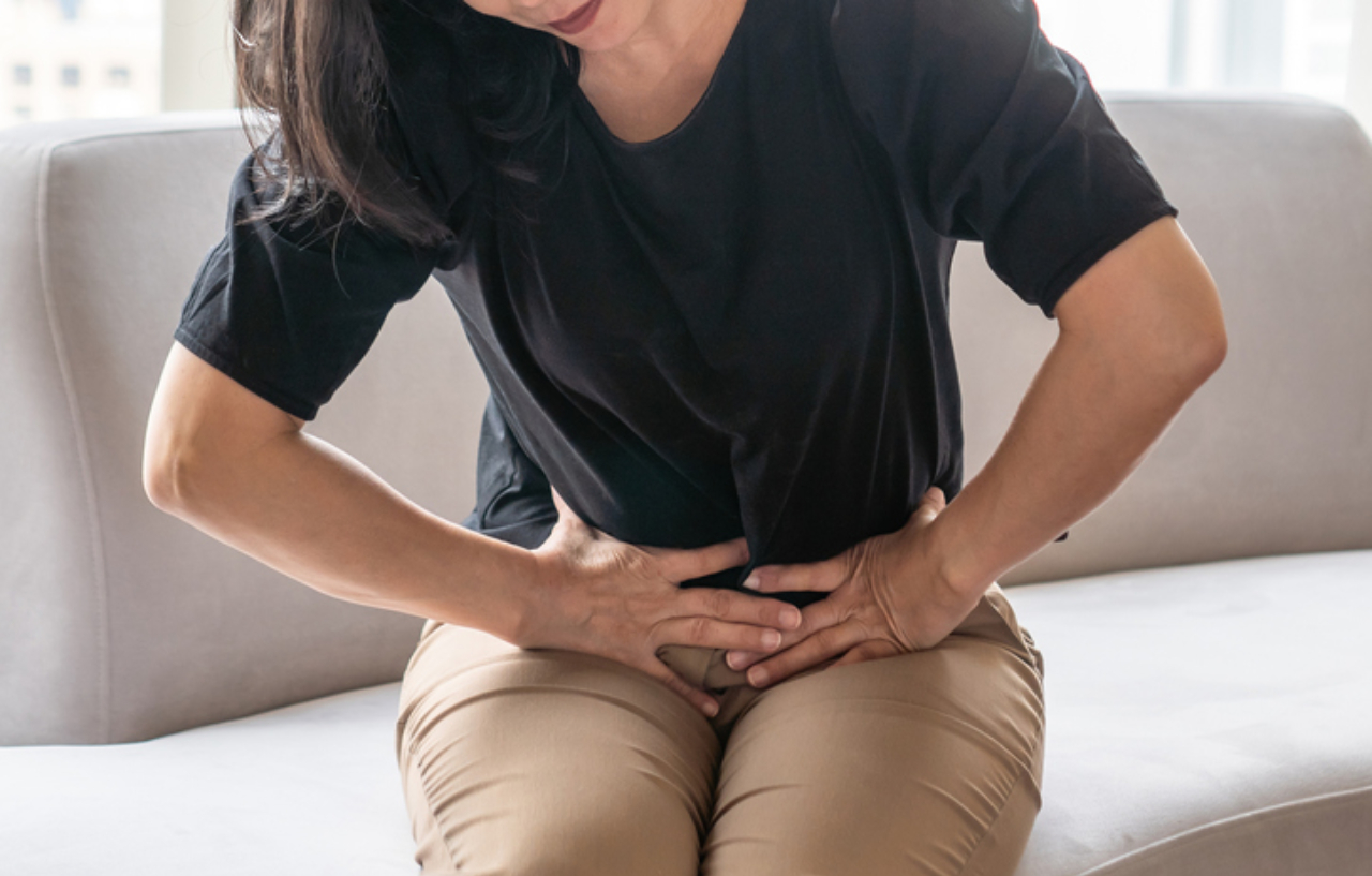 Woman with abdominal pain before she undergoes ulcerative colitis treatment for Inflammatory Bowel Disease