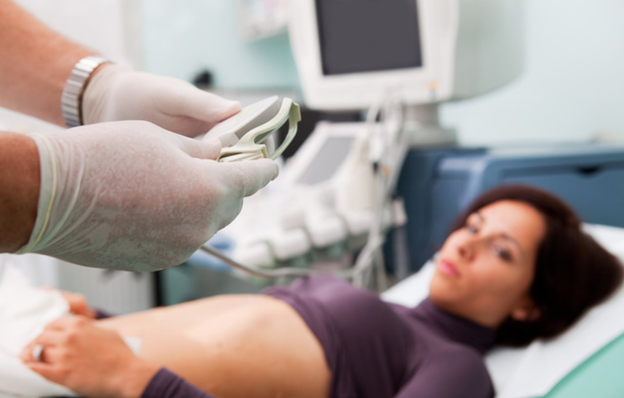 Doctor is performing an ultrasound guided liver biopsy procedure to a woman