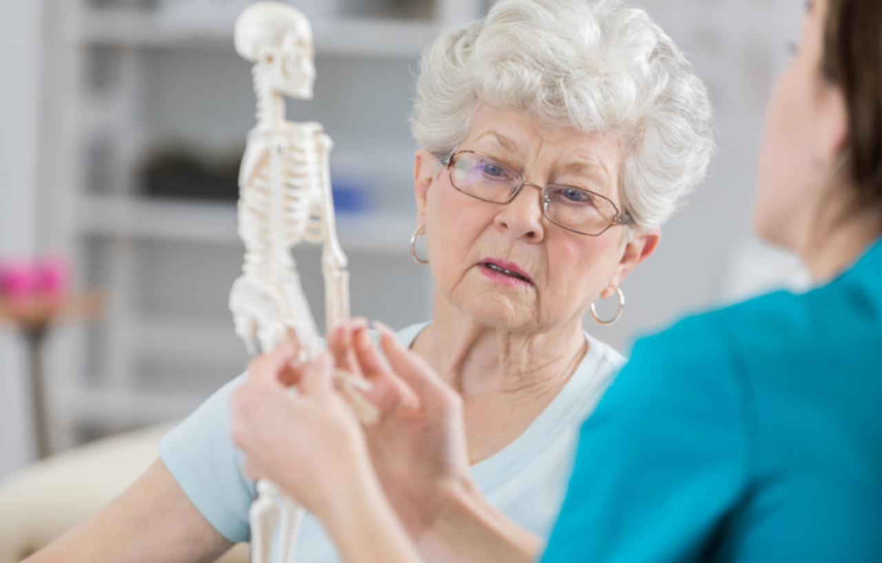 A therapist is discussing the affects of osteoporosis in posture and the reason for resulting pain