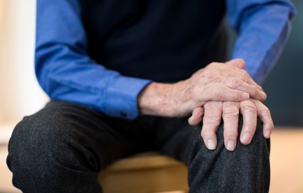 Close up of a man holding a leg tremor before his Parkinson's disease treatment