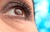 Womans-Brown-Eye-Looking-up-with-Tear-on-Blue-Background