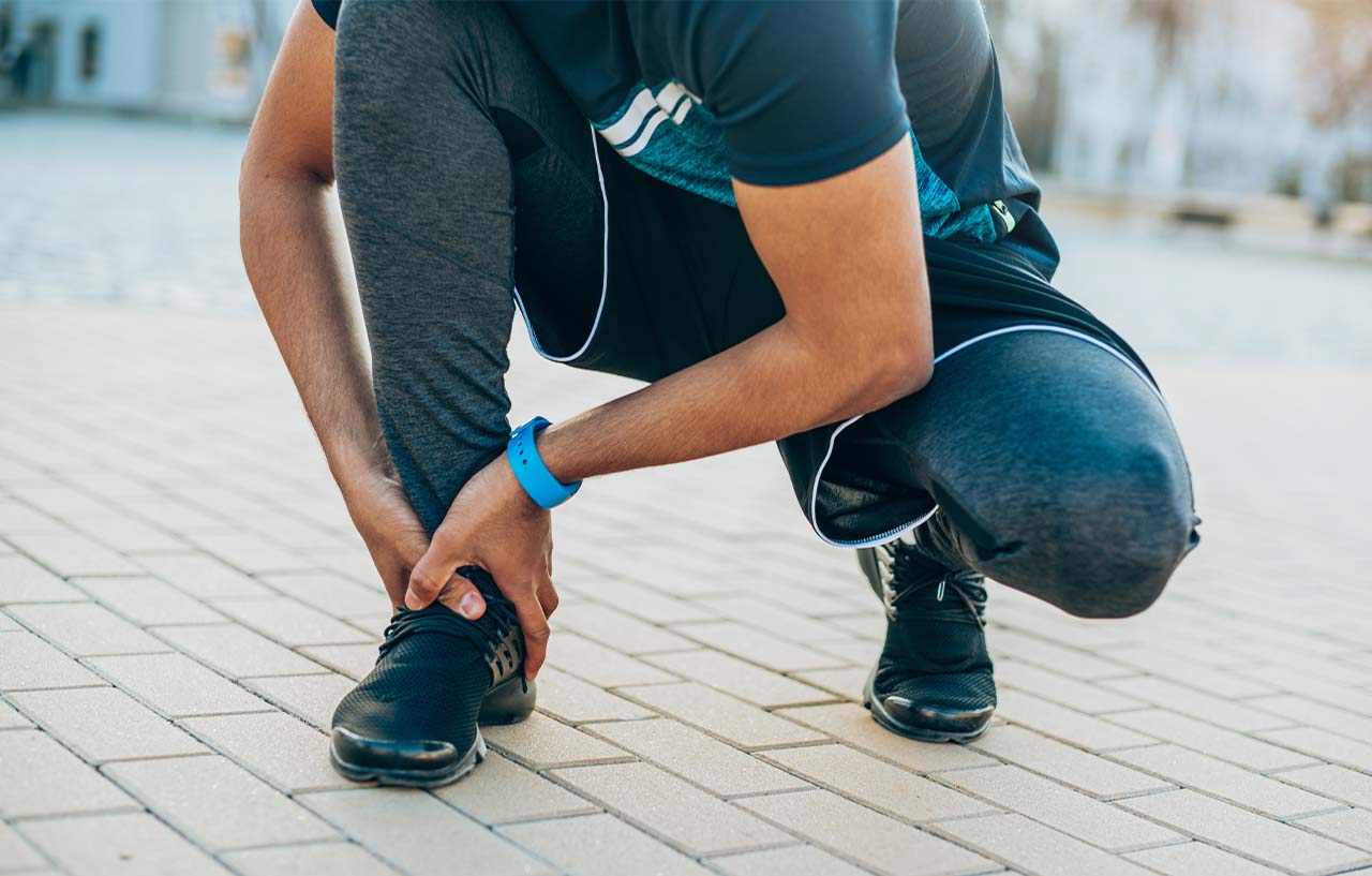 Runner holding his foot after a lateral ankle ligament injury
