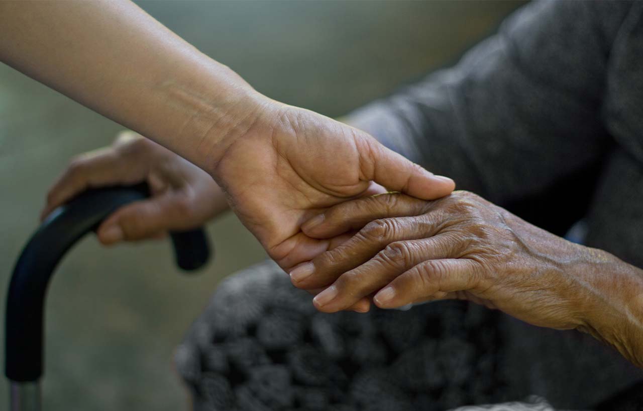 Daughter holds her mother's frail hand caused by soft tissue injuries from wear and tear