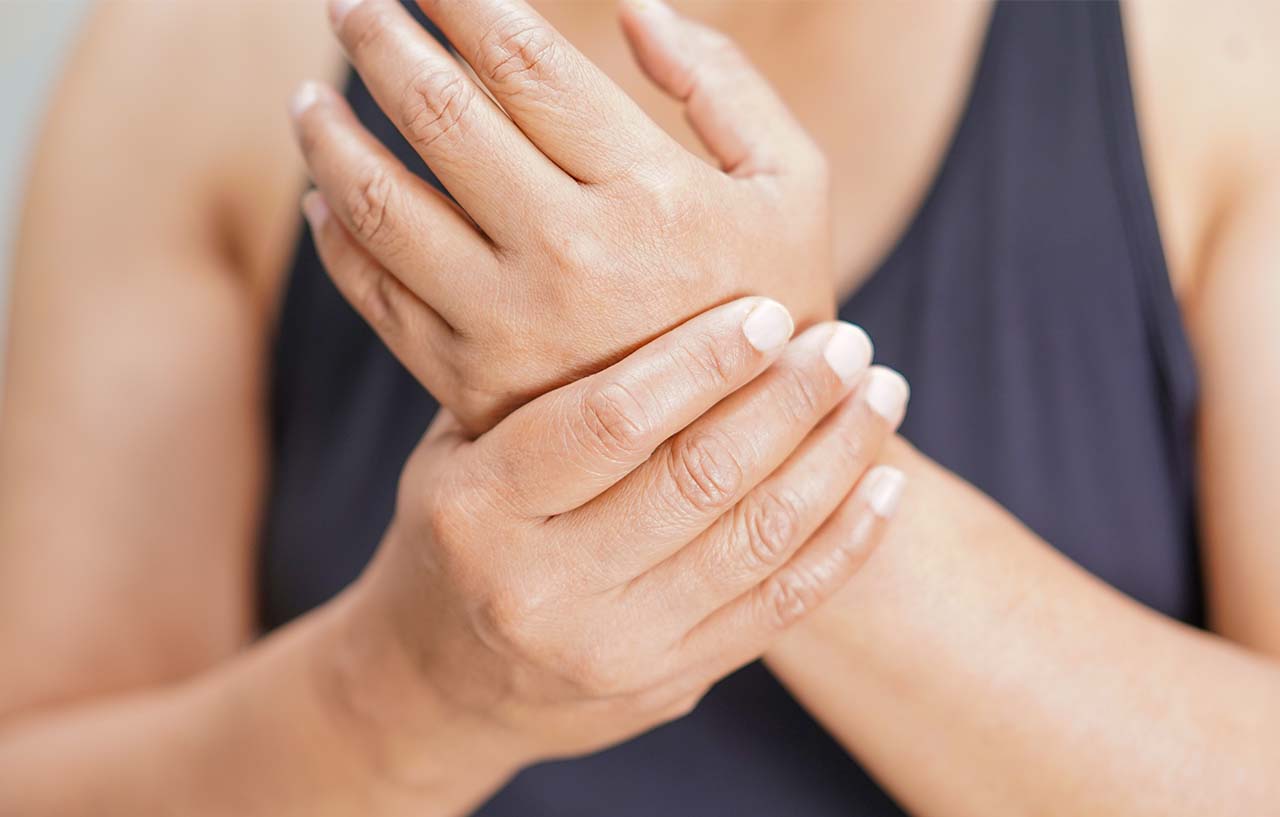Woman holding her hand in pain from her wrist arthritis