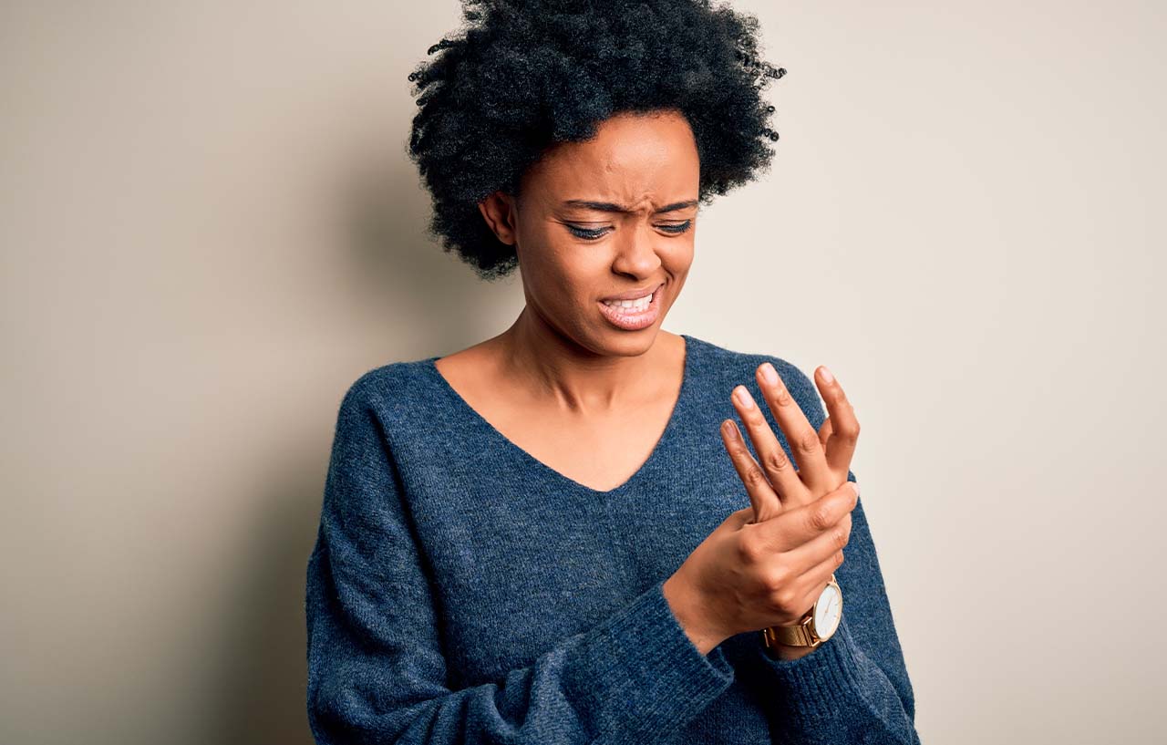 Woman with arthritis of the hand rubs it to try and relieve the discomfort
