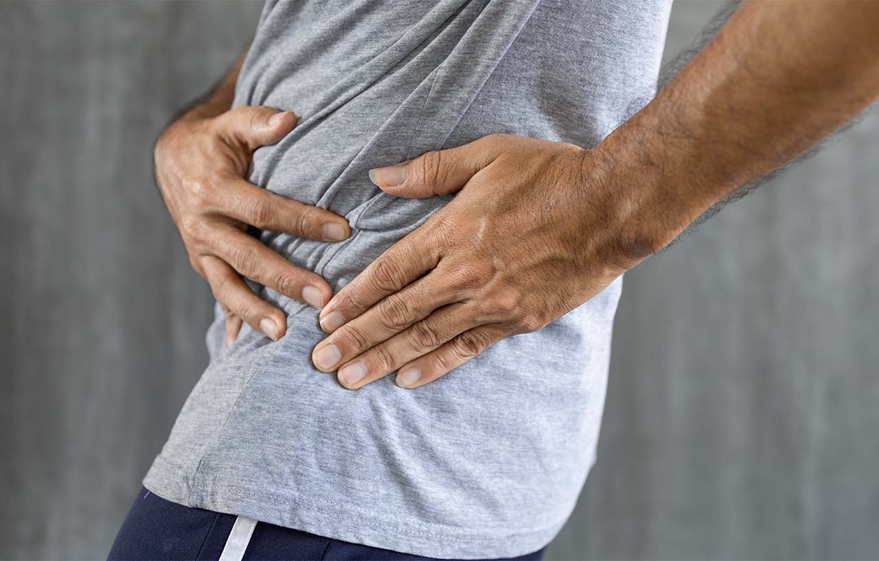 Man with hip arthritis holds his side in pain
