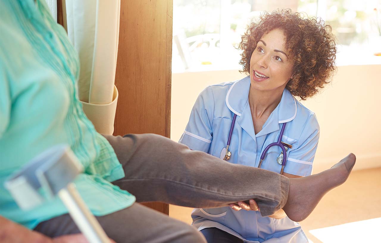 Nurse-giving-patient-medical-knee-assessment