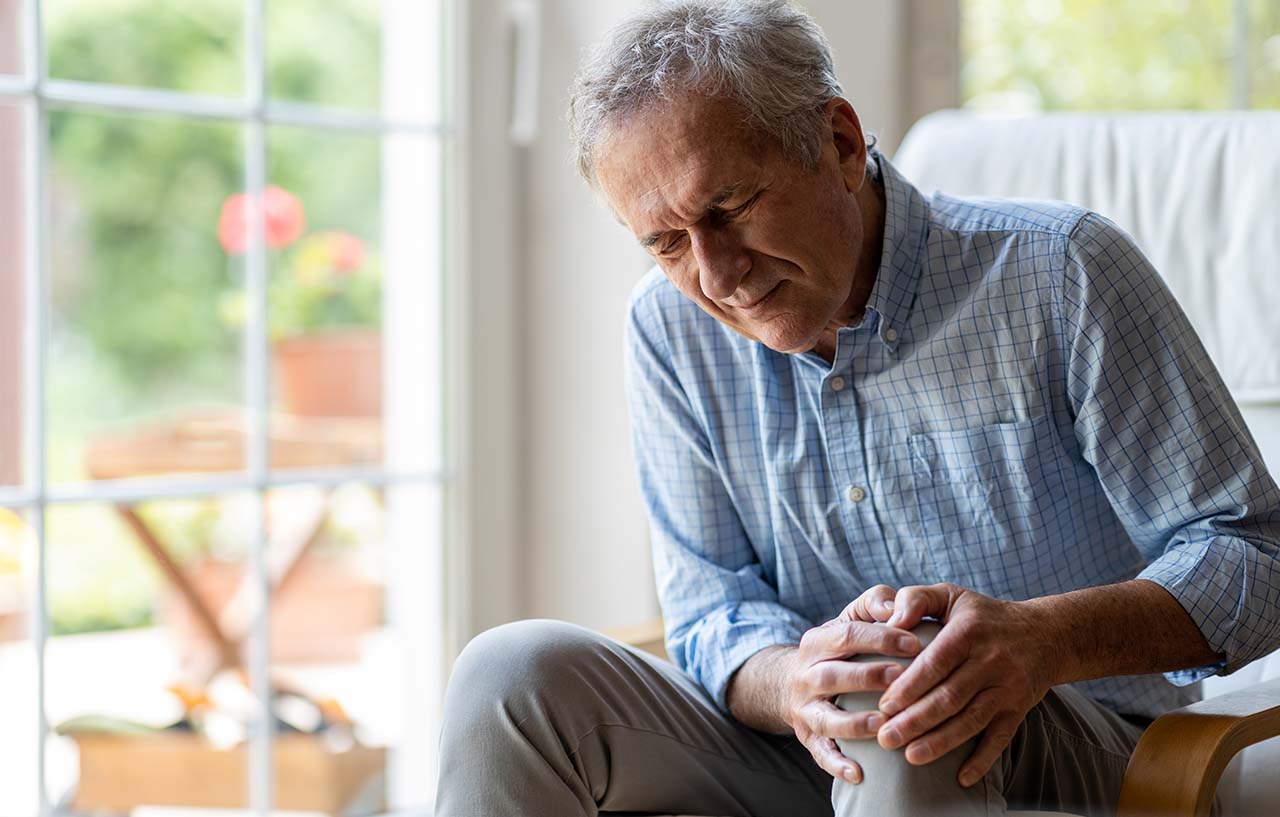 elder man holding his painful knee