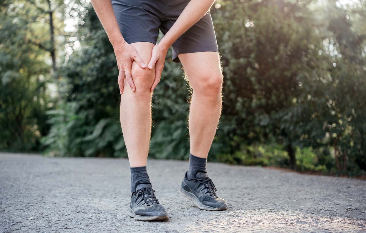 runner holding his painful knee