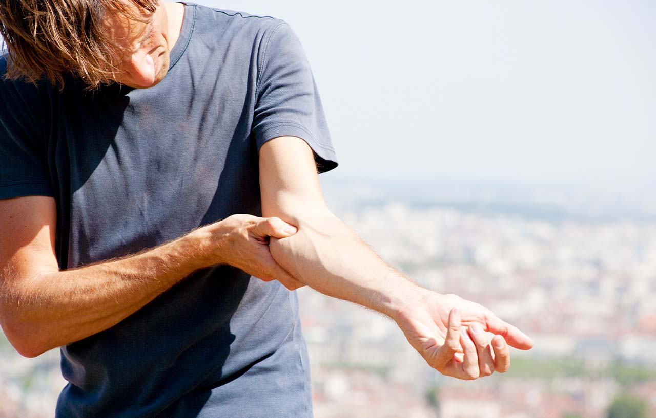Man with a trapped ulnar nerve holds his painful elbow