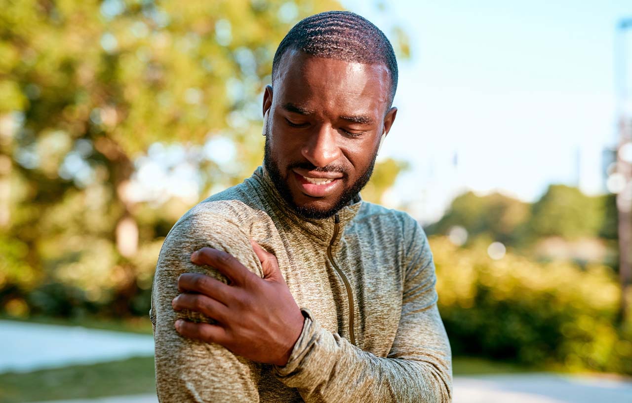 Man with bicep tendon pain holds his shoulder in discomfort