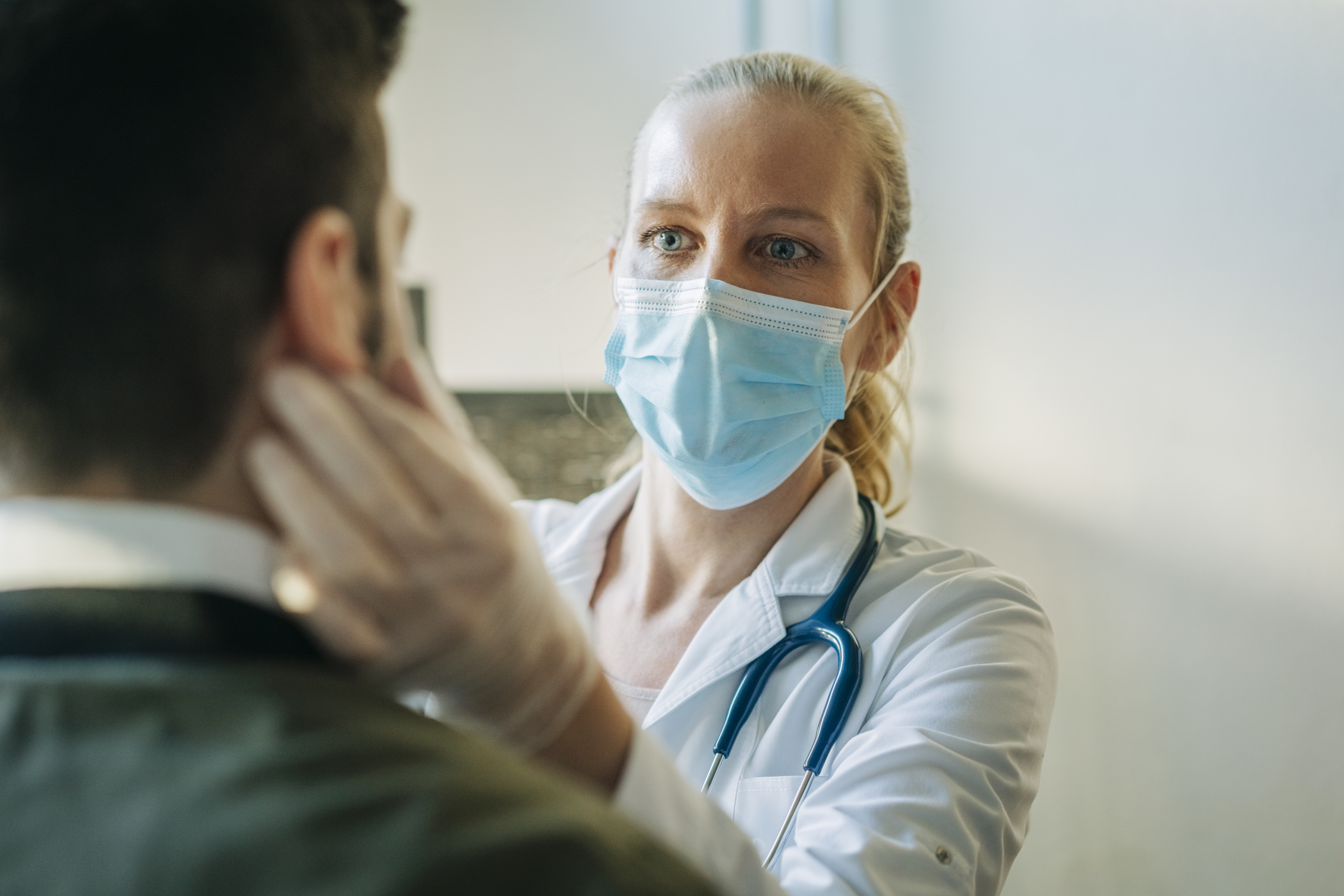 A doctor examines a patient's face