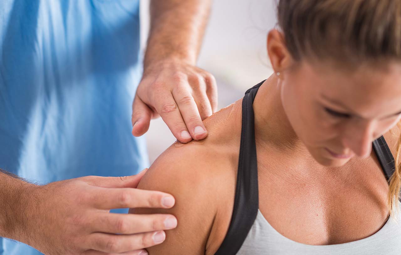 Clinician performing shoulder physiotherapy exercises with a patient