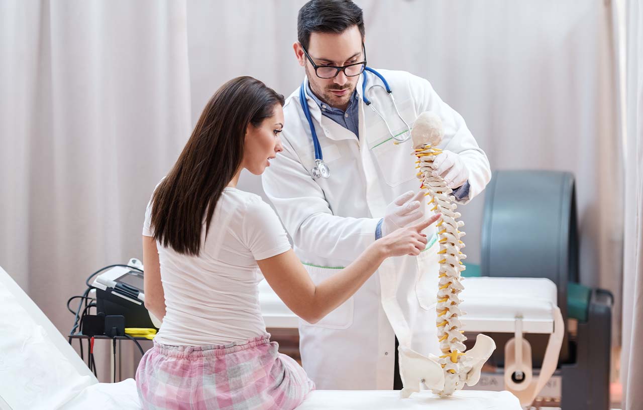 Female patient being shown a medical model of the spine to explain the lateral lumbar interbody fusion prrocedure