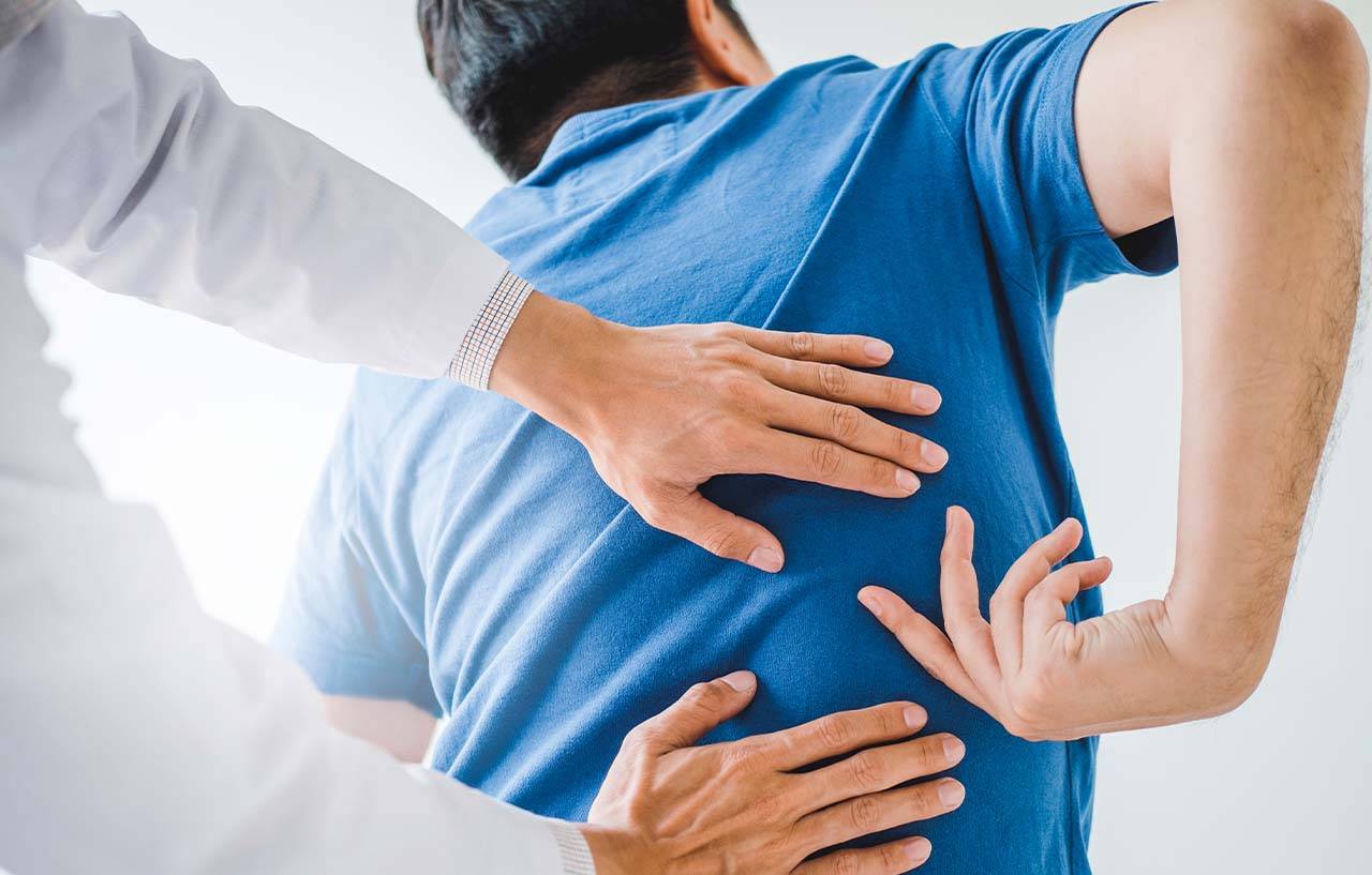 Doctor performing an examination on a man to assess his need for an epidural for back pain