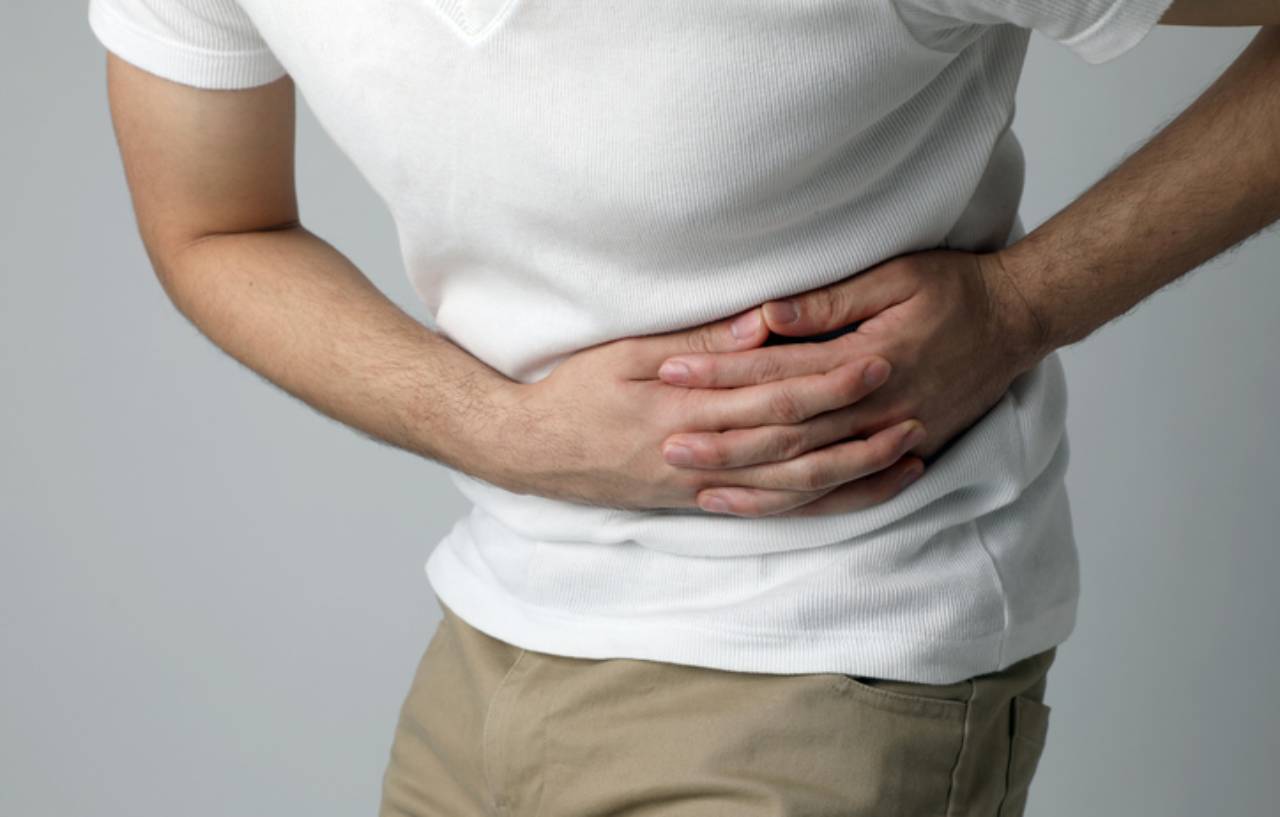 Man holds waist in pain ahead of planned kidney stone treatment